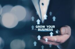 Man holding Grow Your Business words with growth arrows.